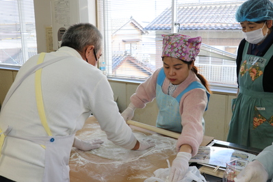 そば生地を伸ばす参加者