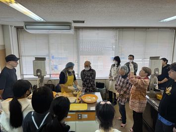 参加者に餃子の作り方を教える講師