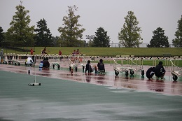 雨のトラックでのハードル競争のようす