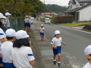 高学年が応援するそばを走っています