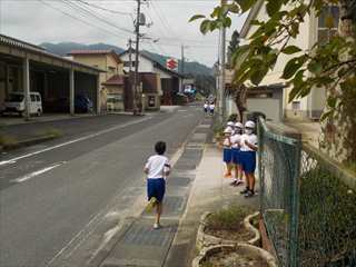 低学年が応援するそばを走って行きます