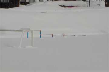 校庭の様子です。鉄棒が雪でほぼ埋まっています。