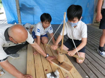 地域の方に押さえていただき、火起し器を動かします。