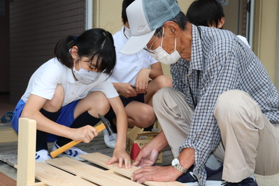 地域の講師の方に押さえていただき、釘を打ち込みます。