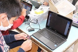 クロームブックにマイクロビットを接続する児童の写真