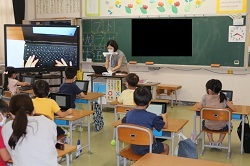 大型提示装置でキーボードの操作を説明する教員の写真