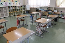 天板拡張くんが設置された机が並ぶ教室の写真