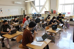 タブレット端末を操作する教職員の写真