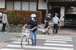 横断歩道を自転車を押してわたる児童の写真