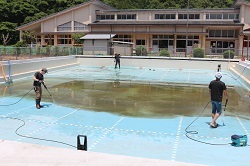 プールを掃除する保護者の写真1