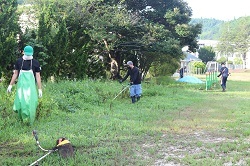 草刈りをする保護者の写真