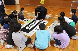 須山局長のお手本を見る児童の写真
