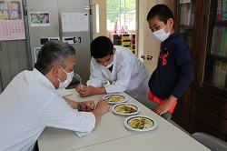 校長室へ出来上がった野菜炒めを持ってきた児童の写真