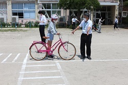 自転車を押して歩く児童の写真