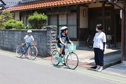 自転車で路上を走行する児童の写真