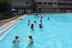 プールでペアで活動をする児童の写真