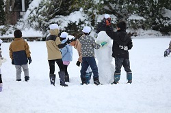 雪だるまをつくる児童の写真