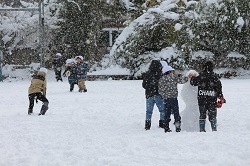 雪だるまを作る児童と雪合戦をする児童の写真