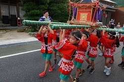 神輿を担ぐ児童の写真