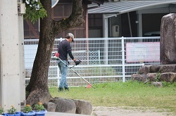 草刈りをする保護者の写真