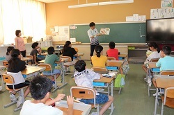 先生の読み聞かせを聞く児童の写真