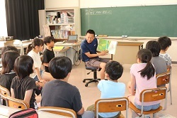 先生の読み聞かせを聞く児童の写真2