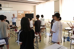 ばちの持ち方を教わる児童の写真