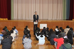 校長先生の話を聞く児童の写真