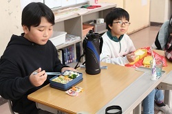 お弁当を食べる児童の写真