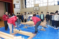 職人さんのお手本を見る児童の写真