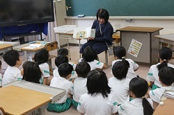 読み聞かを聞く児童の写真1