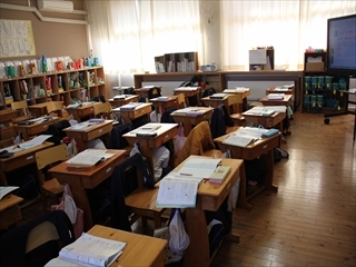 机の下に隠れています。