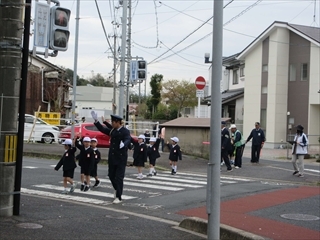 手を挙げて横断歩道を渡ります。