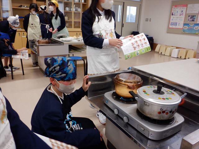 ご飯を炊く火加減は、教科書で確認しながら調理している児童
