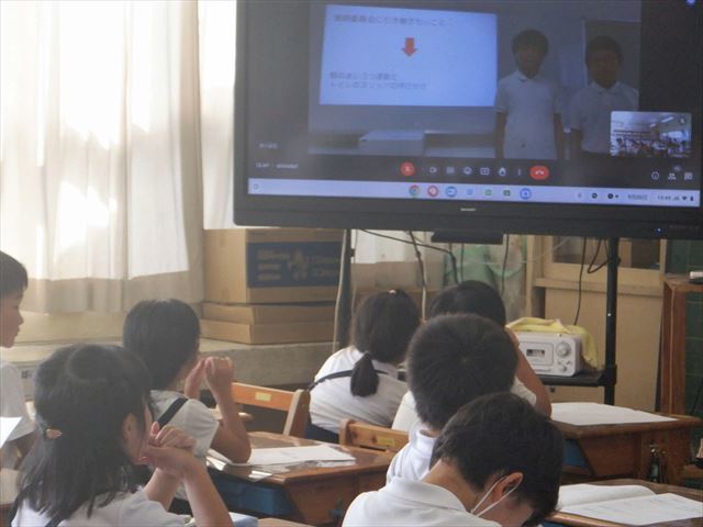 教室から6年生の委員会の発表を聞く１年生