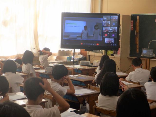 教室で6年生の委員会発表を聞く2年生
