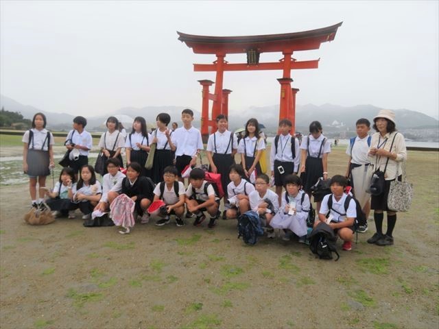 宮島の鳥居に前で記念撮影をする6年生