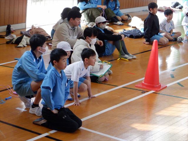身を乗り出して、同じ班の児童を応援する児童