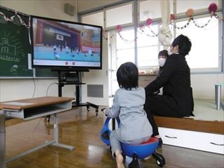 特別支援学級ビックパッドを保護者と児童が見ています