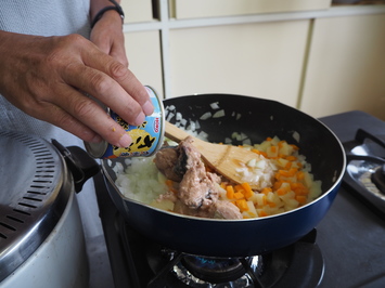 サバ缶をフライパンに入れている様子