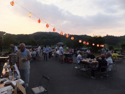 屋外での納涼会の様子。提灯が飾られています。