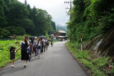 親子連れやお年寄りが道路をあるいている様子