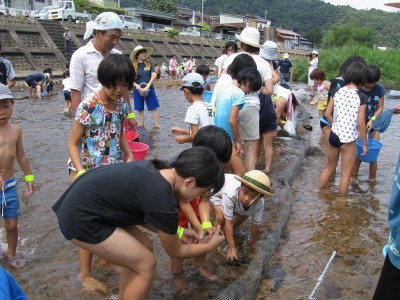 にじますのつかみ取りする男の子の様子