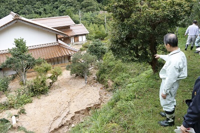 土砂崩れが起きた現場を視察する近藤市長。