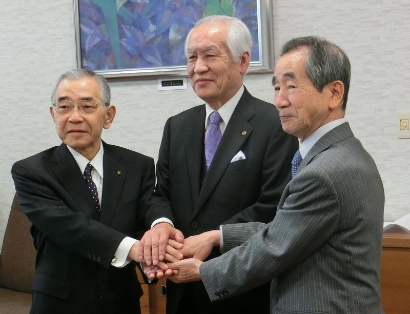 調印式で握手を交わす溝口知事、木口社長、近藤市長。