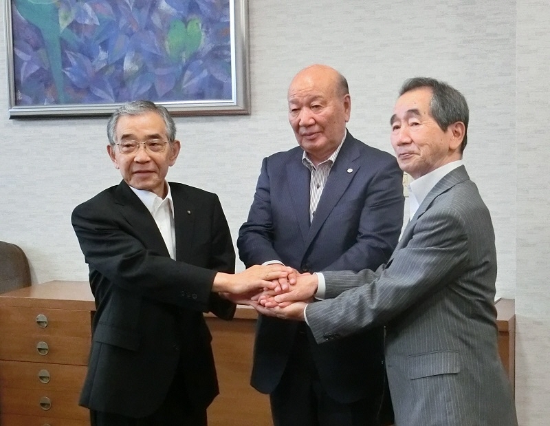 調印後、握手を交わす溝口知事、豊嶋社長、近藤市長。