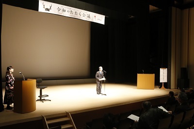 ステージの上で挨拶を述べる近藤市長の写真