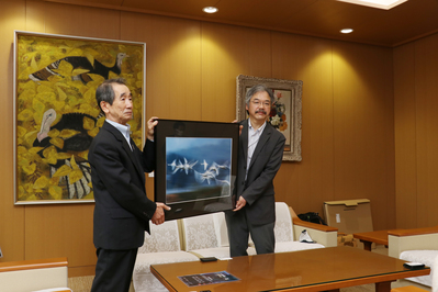 額縁入りの写真を手に持っている廣池さんと近藤市長の写真